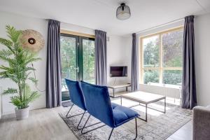 a living room with blue chairs and a table at 5 - Person Forest 239 Sauna Bungalow in Ewijk