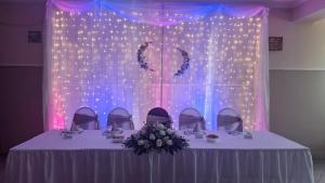 a table with a bunch of flowers and lights at Liebner-kerti Vendégház in Kakucs