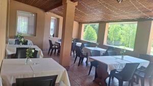 a restaurant with tables and chairs with white table cloth at Liebner-kerti Vendégház in Kakucs