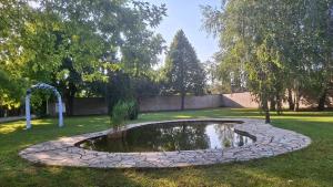 a small pond in the middle of a garden at Liebner-kerti Vendégház in Kakucs