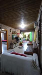 una camera da letto con due letti e un soggiorno di Pousada e Residencial Linda a Capão da Canoa