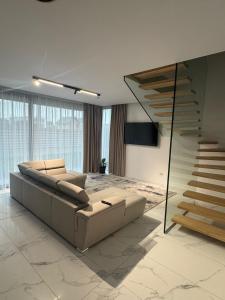 a living room with a couch and a staircase at KNIGHT Villa in Voluntari