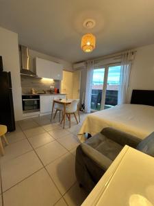 a bedroom with a bed and a table and a kitchen at Studio a 3 mn à pied des thermes in Balaruc-les-Bains