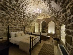 a bedroom with a bed in a stone wall at Mara Loya Konağı in Mardin +79 photos
