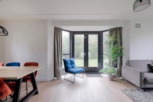 a living room with a blue chair and a table at 6 - Persons Lakeside 7 Bungalow in Ewijk