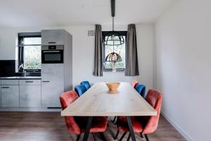 a kitchen and dining room with a table and chairs at 6 - Persons Lakeside 7 Bungalow in Ewijk