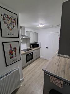 a kitchen with white cabinets and a counter top at Millburn Chalet in Inverkip +4 photos