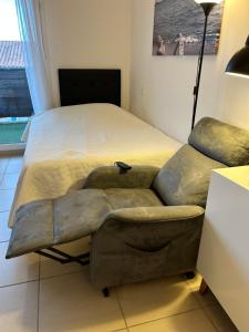a bedroom with a bed and a couch at Studio a 3 mn à pied des thermes in Balaruc-les-Bains