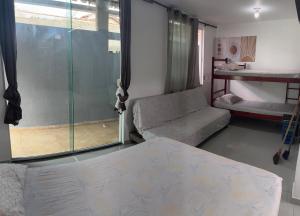 een kamer met een bed en een glazen schuifdeur bij Kitnet em Cabo Frio 02 in Cabo Frio +15 foto's