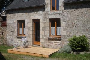 una casa con un ponte di legno di fronte ad essa di belle maison de campagne a Hénon Altre 8 foto