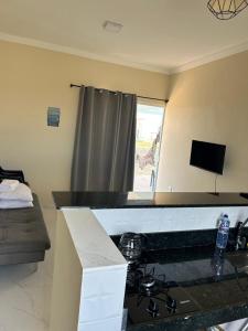a kitchen with a stove and a counter top at Ventos de Arubinha - Apto Inteiro - Reserva a partir de 04 dias em Janeiro e Fevereiro in Arraial do Cabo