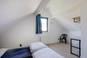 a bedroom with a bed and a desk and a window at 6 - Persons Lakeside 25 Bungalow in Ewijk