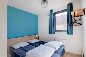 two beds in a room with blue and white walls at 6 - Persons Lakeside 25 Bungalow in Ewijk +22 photos