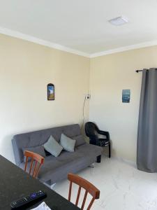 a living room with a couch and a table and chairs at Ventos de Arubinha - Apto Inteiro - Reserva a partir de 04 dias em Janeiro e Fevereiro in Arraial do Cabo