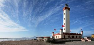 a lighthouse on a beach with a blue sky at Mi casa es tu casa in La Serena +7 photos
