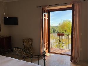 a bedroom with a door open to a balcony at Tenuta degli Ulivi - Dimora Contadina in Montecorvino Rovella