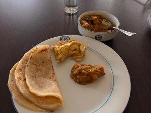 a plate of food with chicken and a bowl of soup at The Pavilion at Riverside Park in Kāundia