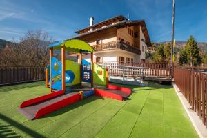 a playground in front of a house at Al Piol in San Nicolò di Comelico