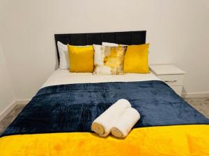 a yellow and blue bed with two towels on it at Cherry Barn Haven in Wisbech Saint Mary
