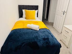 a bedroom with a bed with a yellow and blue blanket at Cherry Barn Haven in Wisbech Saint Mary +1 photo
