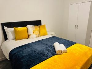 a bed with yellow and blue sheets and yellow pillows at Cherry Barn Haven in Wisbech Saint Mary