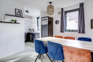 a kitchen and dining room with a table and blue chairs at 6 - Persons Lakeside 61 Bungalow in Ewijk +32 photos