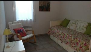 a bedroom with a bed and a chair and a window at Residencia Odyssee in Vieux-Boucau-les-Bains