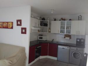 a kitchen with white cabinets and a washing machine at Residencia Odyssee in Vieux-Boucau-les-Bains