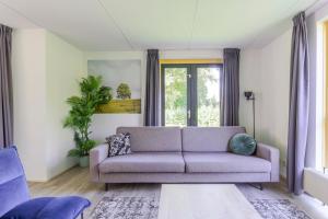 a living room with a couch and a window at 4-Person Forest 159 Bungalow in Ewijk