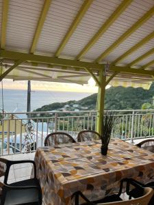 a table with chairs and a table cloth on a patio at Milles Eclats in Les Anses-dʼArlets