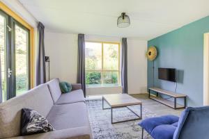 a living room with a couch and a tv at 4-Person Forest 159 Bungalow in Ewijk