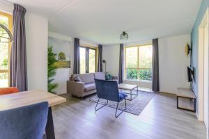 a living room with a table and a couch at 4-Person Forest 159 Bungalow in Ewijk
