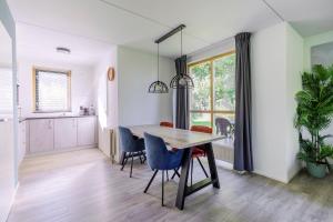 a kitchen and dining room with a table and chairs at 4-Person Forest 159 Bungalow in Ewijk