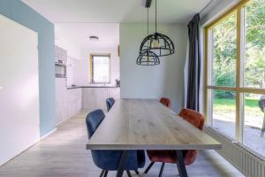a kitchen and dining room with a wooden table and chairs at 4-Person Forest 159 Bungalow in Ewijk +29 photos