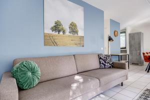 a living room with a couch and a painting on the wall at 6 - Persoons Forest 67 Bungalow in Ewijk