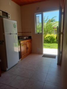 a kitchen with a white refrigerator and a window at Departamentos RIMASHA in Federación