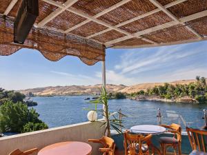 a view of a river from a patio with tables and chairs at Villa Swenet in Aswan