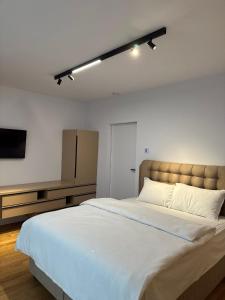 a bedroom with a large bed and a flat screen tv at KNIGHT RESORT Villa & Rooms in Voluntari