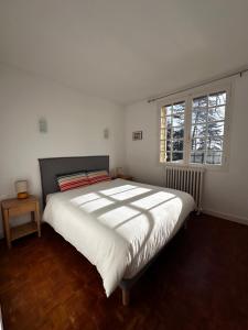 a bedroom with a large bed and a window at LES HAUTS DE TREMOLAT in Trémolat