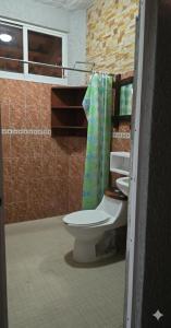 een badkamer met toilet en douchegordijn bij Casa El Limón in Zihuatanejo +1 foto