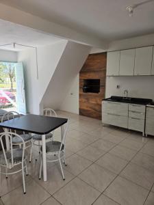 a kitchen and dining room with a table and chairs at Vida Mansa Apartamentos in Capão Novo