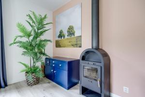 a fireplace in a living room with a plant at 5-Person Forest 271 Bungalow in Ewijk