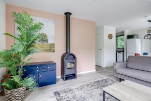 a living room with a fireplace and a couch at 5-Person Forest 271 Bungalow in Ewijk