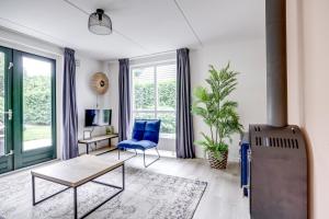 a living room with a blue chair and a table at 5-Person Forest 271 Bungalow in Ewijk