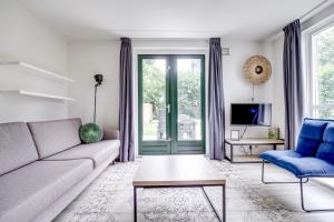 a living room with a couch and a tv at 5-Person Forest 271 Bungalow in Ewijk