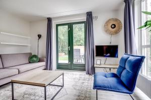 a living room with a couch and a table at 5-Person Forest 271 Bungalow in Ewijk +37 photos