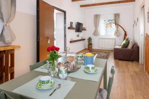 a table with two cups and a vase of flowers on it at Agata's House in Viagrande +11 photos