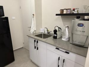 a kitchen with a sink and a black refrigerator at סוויטת ארגמן in Beʼer Ora