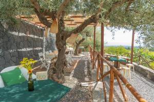 a table with flowers on it under a tree at Agata's House in Viagrande