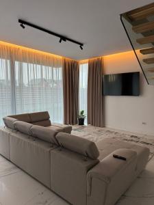 a living room with a large couch and a flat screen tv at KNIGHT RESORT Villa & Rooms in Voluntari